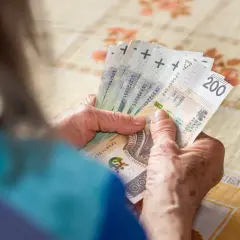 Dłonie starszej osoby liczą banknoty 200 zł. To może być oczekiwana 14 emerytura 2025 netto.