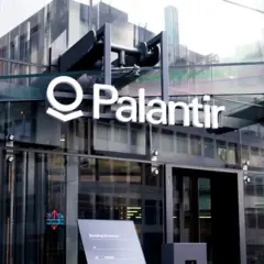 Logo Palantir na nowoczesnym budynku z przeszkloną fasadą.