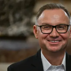 Uśmiechnięty mężczyzna w okularach, w garniturze. Czyżby planował już emeryturę prezydencką?