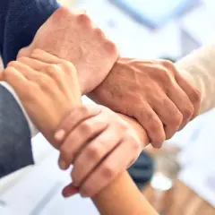 Dłonie splecione w geście współpracy, symbolizujące siłę networkingu i wspólnego celu.