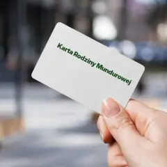 Karta Rodziny Mundurowej w dłoni. Dokument uprawniający do zniżek dla rodzin mundurowych.