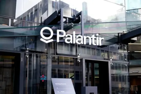 Logo Palantir na nowoczesnym budynku z przeszkloną fasadą.
