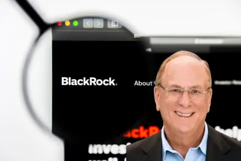 Larry Fink, CEO BlackRock, zarządza ogromnymi aktywami. Na ekranie logo firmy i hasło "About us".