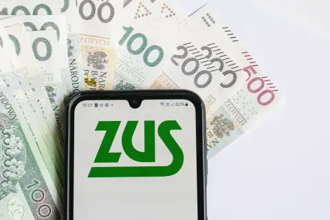 Telefon z logo ZUS na tle polskich banknotów. Czy to zapowiedź 13 emerytury 2026? Tabela z wypłatami wkrótce.