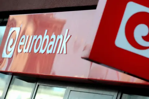 Logo eurobank na czerwonym tle. Obok widoczny fragment czerwonego kwadratu z białym znakiem.