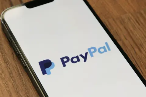 Na ekranie telefonu widnieje logo PayPal. Czy PayPal jest bezpieczny? To pytanie zadaje sobie wiele osób przed dokonaniem płatności.