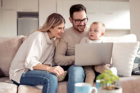 Rodzina ogląda coś na laptopie. Zastanawiają się, czy świadczenie socjalne wlicza się do dochodu, planując przyszłość.
