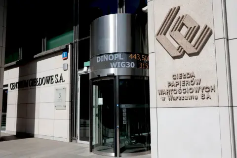 Budynek Giełdy Papierów Wartościowych w Warszawie. Na fasadzie widnieje napis "CENTRUM GIEŁDOWE S.A." oraz logo. Obok obrotowych drzwi wyświetlane są kursy akcji, np. WIG30. To miejsce, gdzie inwestorzy, jak ci z Rafako, śledzą rynek.