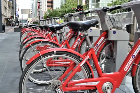 Rzędy czerwonych rowerów miejskich Houston B-cycle, gotowych do wypożyczenia. To świetny przykład **saas** w transporcie miejskim.