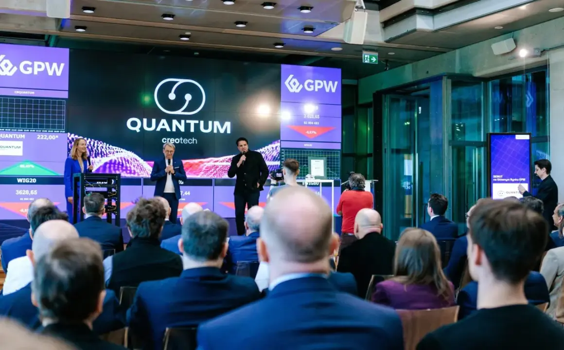 Prezentacja Quantum creotech na GPW. Na ekranie widać notowania i logo firmy.