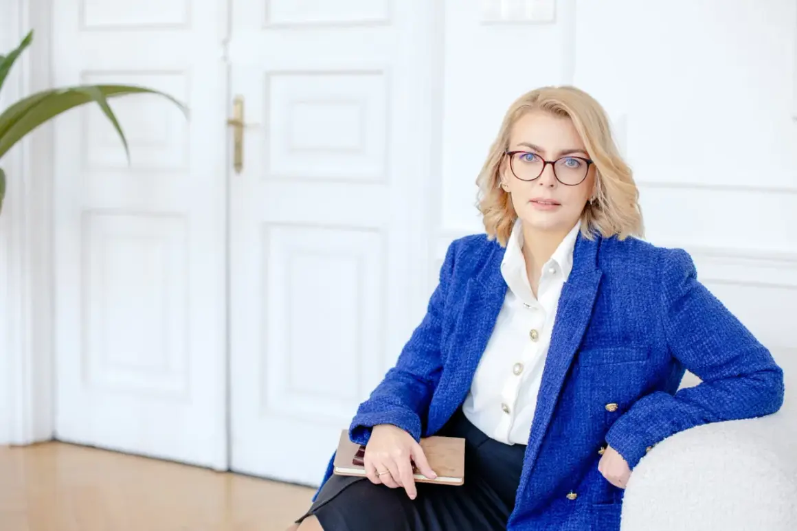 Kobieta w okularach i niebieskiej marynarce trzyma notatnik. Planujesz otwarcie firmy w 2025? Sprawdź dostępne dotacje!