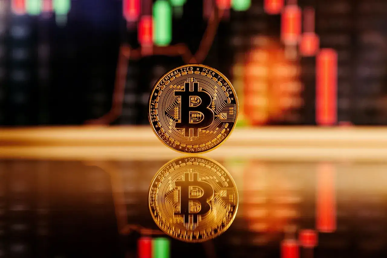 Złoty bitcoin na tle wykresu giełdowego. Zastanawiasz się, ile pieniędzy zainwestować w bitcoin?