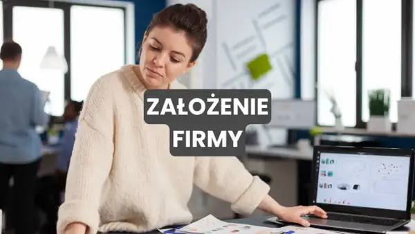 Kobieta analizuje dane na laptopie, przygotowując się do założenia firmy. W tle biuro.