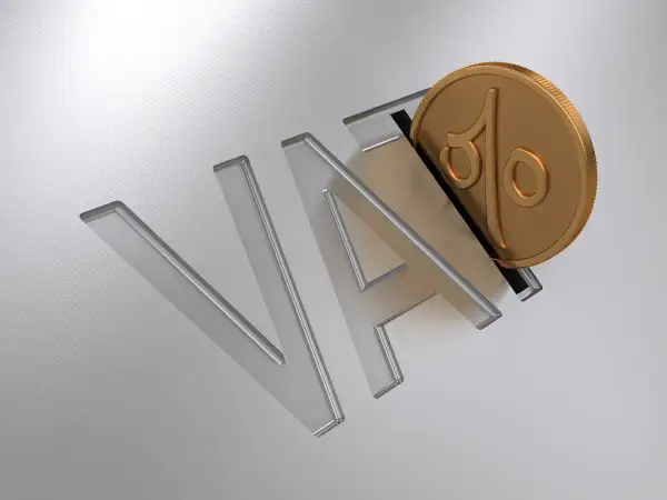 Złota moneta z symbolem procentu wpada do litery "A" w napisie "VAT".