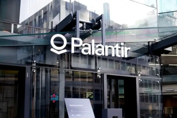 Logo Palantir na nowoczesnym budynku z przeszkloną fasadą.