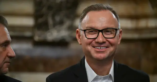 Uśmiechnięty mężczyzna w okularach, w garniturze. Czyżby planował już emeryturę prezydencką?