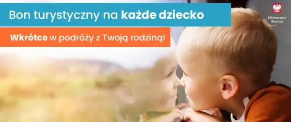 Bon turystyczny na każde dziecko. Wkrótce w podróży z Twoją rodziną! Mały chłopiec patrzy przez okno, marząc o wakacjach.