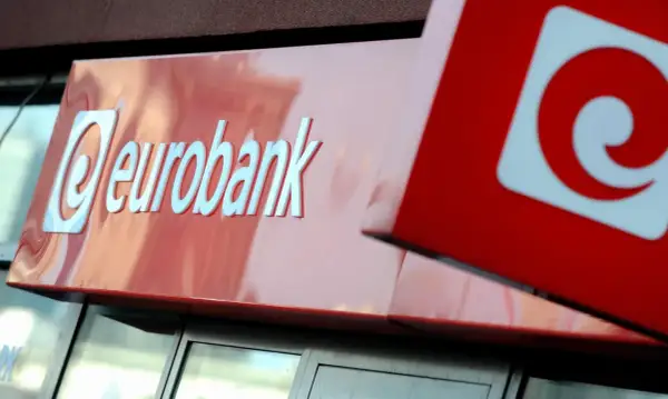 Logo eurobank na czerwonym tle. Obok widoczny fragment czerwonego kwadratu z białym znakiem.